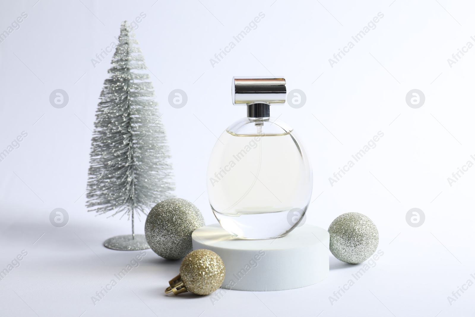 Photo of Stylish composition of perfume bottle and Christmas decor on white background