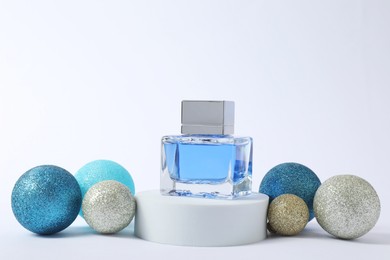 Christmas composition of perfume bottle and baubles on white background