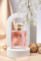 Photo of Stylish composition of perfume bottle and Christmas decor on white background