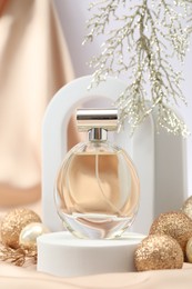 Photo of Stylish composition of perfume bottle and Christmas decor on white background