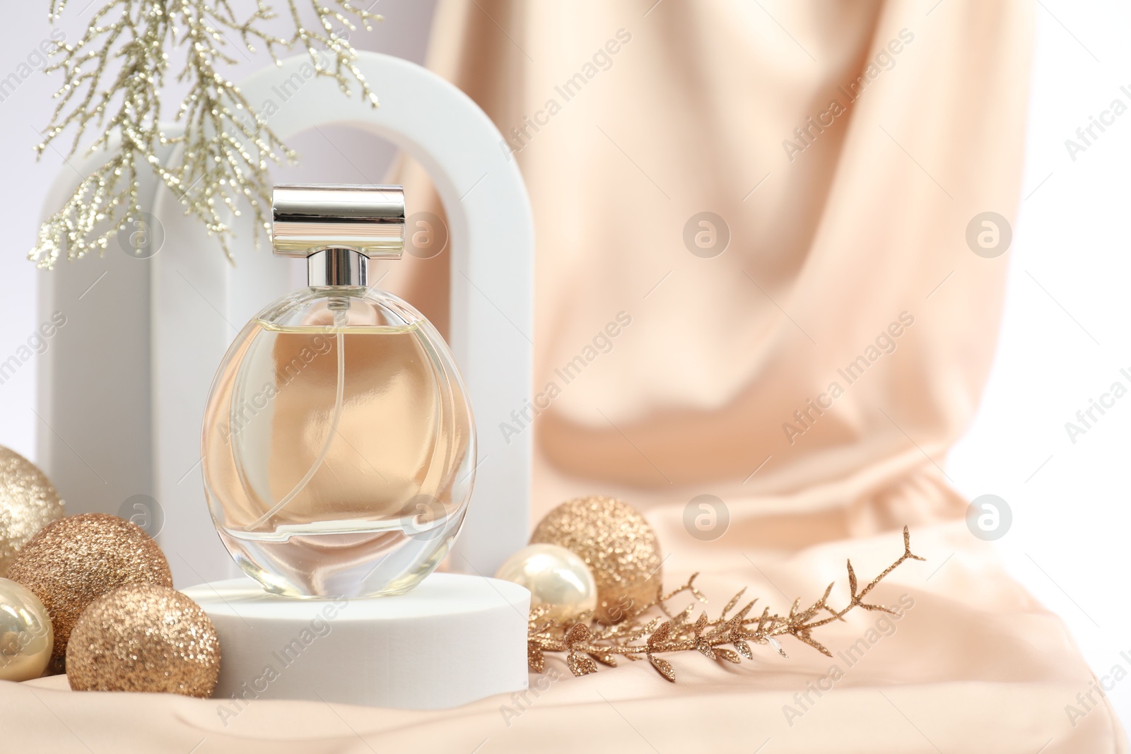 Photo of Stylish composition of perfume bottle and Christmas decor on white background. Space for text