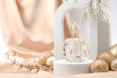 Photo of Stylish composition of perfume bottle and Christmas decor on white background. Space for text