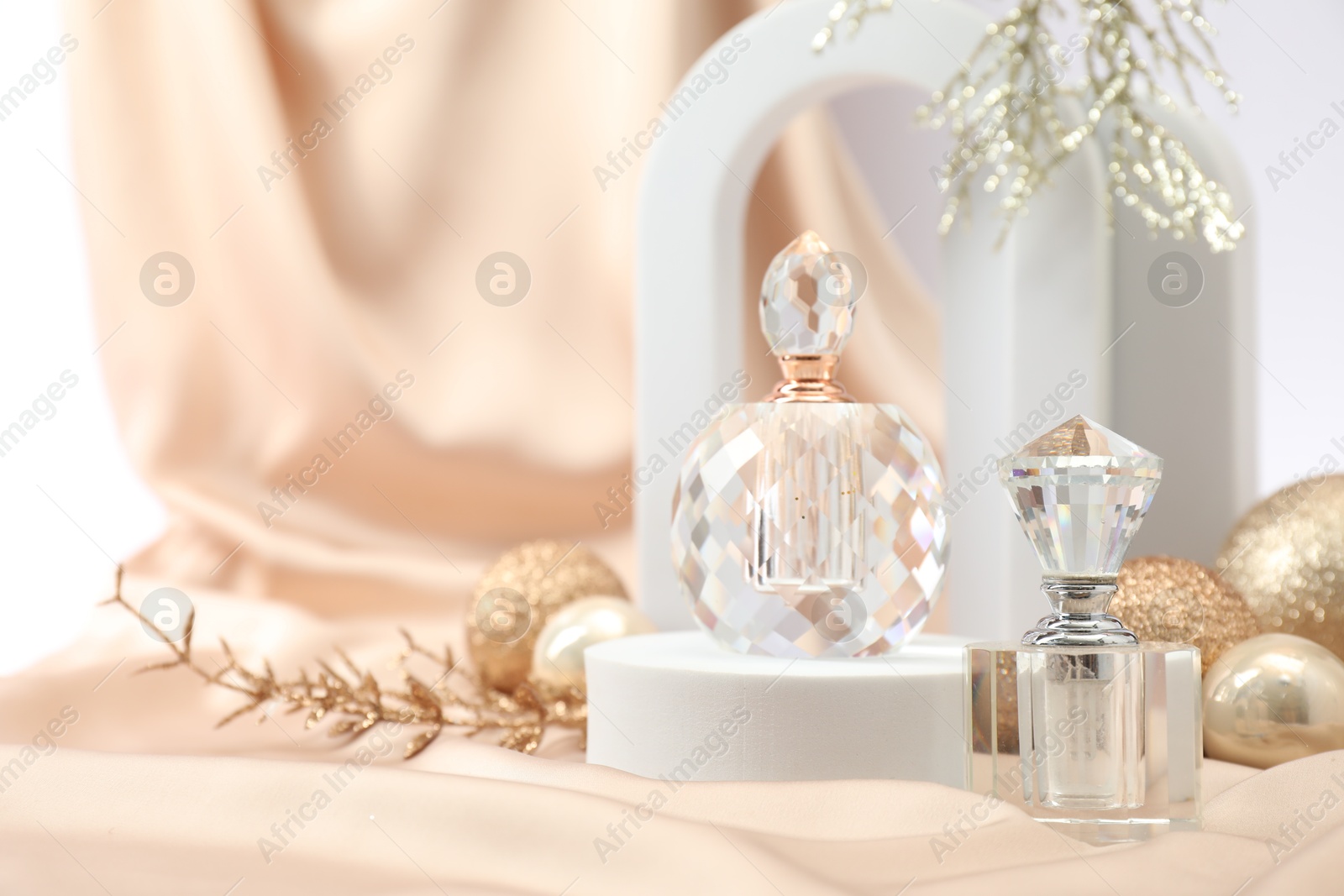 Photo of Stylish composition of perfume bottle and Christmas decor on white background. Space for text