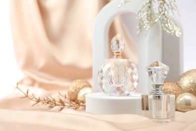 Photo of Stylish composition of perfume bottle and Christmas decor on white background. Space for text