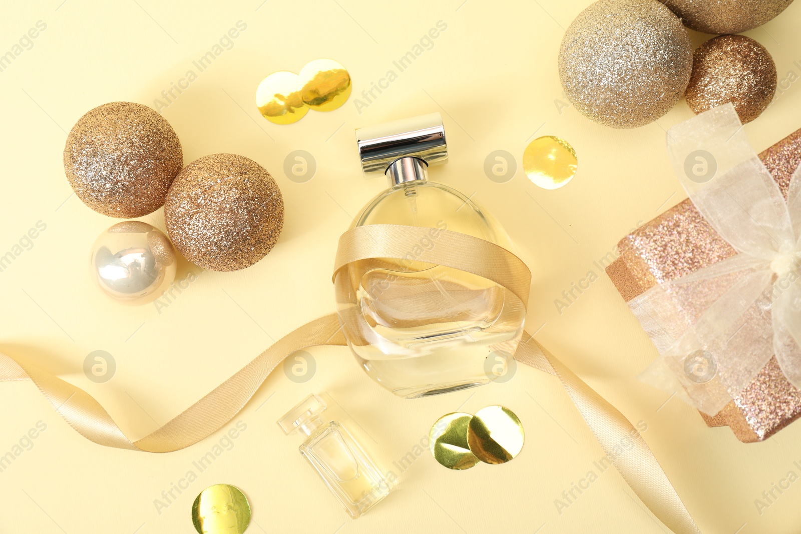 Photo of Christmas composition with perfume bottle on beige background, flat lay