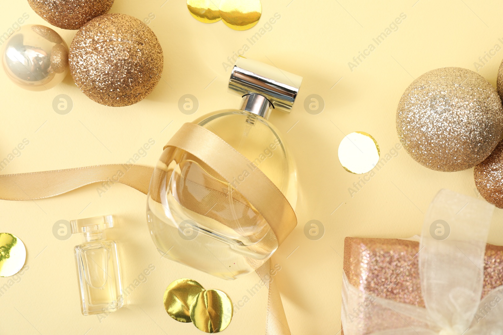 Photo of Christmas composition with perfume bottle on beige background, flat lay