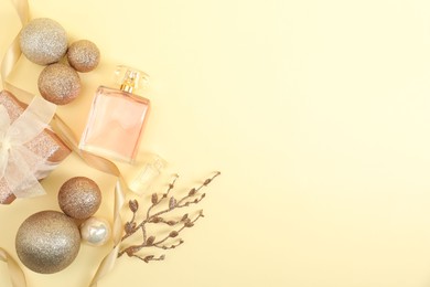 Photo of Christmas composition with perfume bottle on beige background, flat lay. Space for text