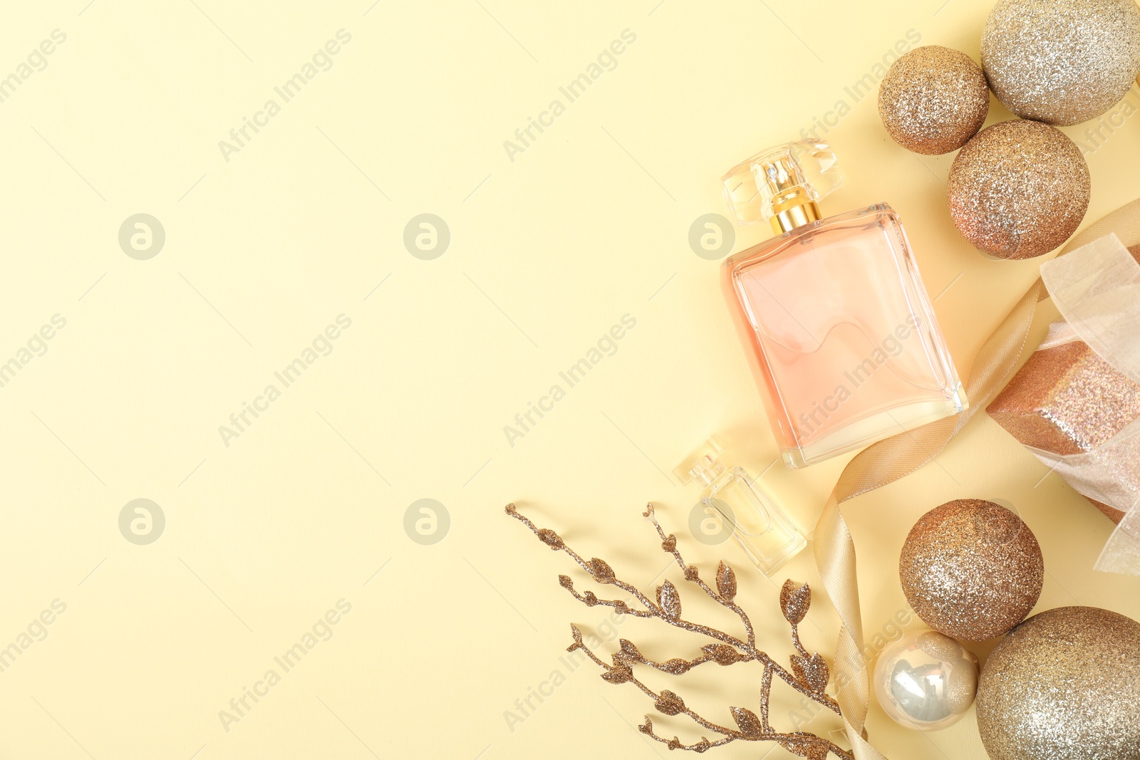 Photo of Christmas composition with perfume bottle on beige background, flat lay. Space for text