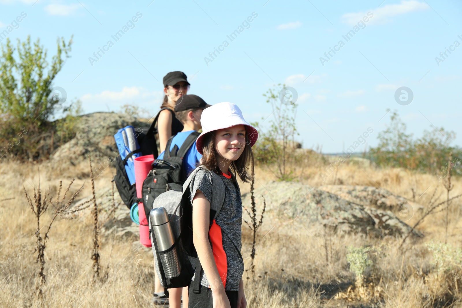 Photo of Family with backpacks travelling outdoors on sunny day