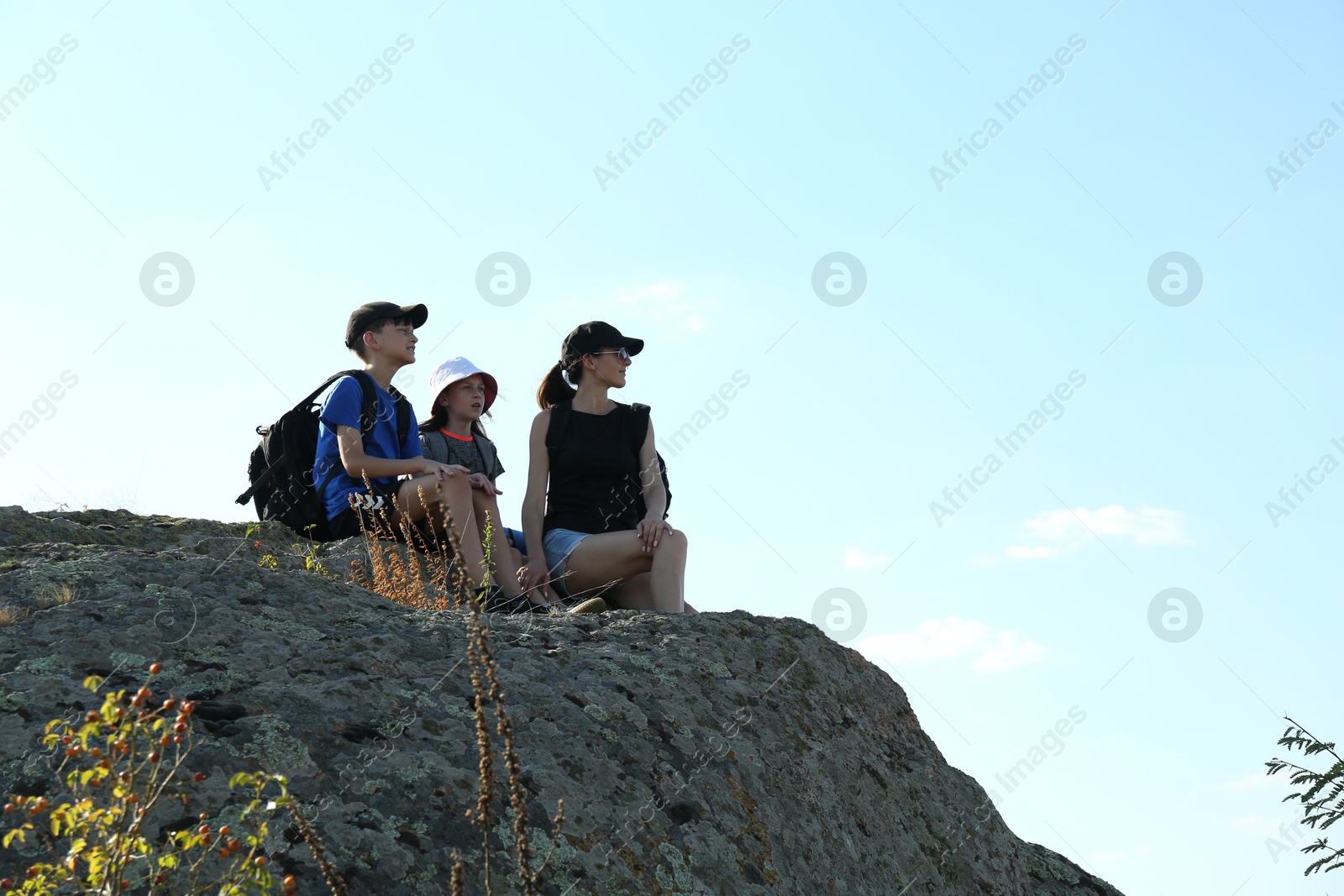 Photo of Cute family enjoying picturesque landscape on stone