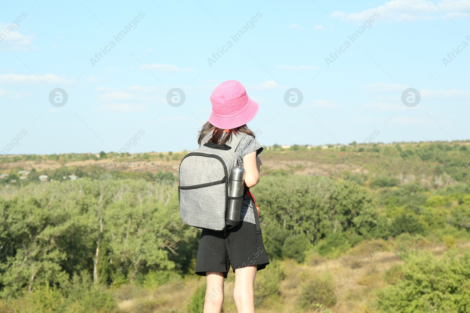 Photo of Little girl enjoying picturesque landscape, back view