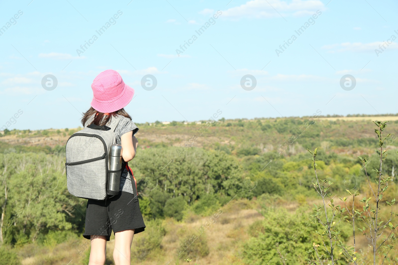 Photo of Little girl enjoying picturesque landscape, back view. Space for text