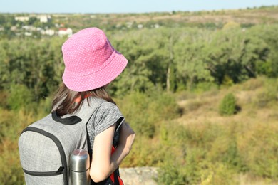 Photo of Little girl enjoying picturesque landscape, back view. Space for text