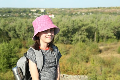 Photo of Portrait of little girl with backpack outdoors on sunny day. Space for text