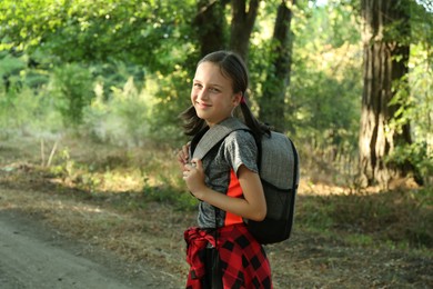 Photo of Portrait of cute little girl travelling in beautiful forest