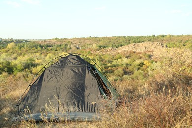 Photo of One camping tent among plants outdoors on sunny day. Space for text