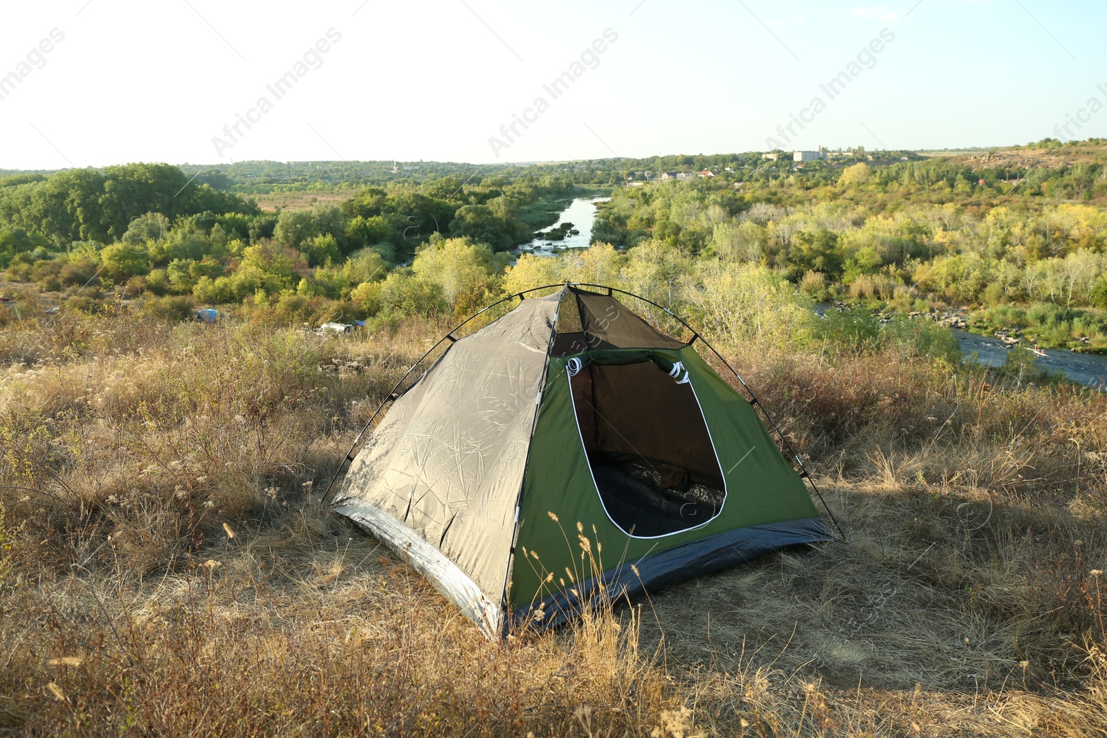 Photo of One camping tent among plants outdoors on sunny day