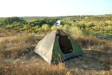 One camping tent among plants outdoors on sunny day