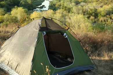 Photo of One camping tent among beautiful plants outdoors