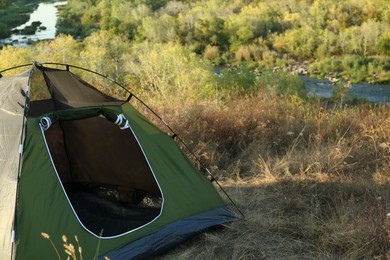 Photo of One camping tent among plants outdoors. Space for text