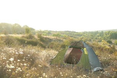 Photo of One camping tent among plants outdoors. Space for text