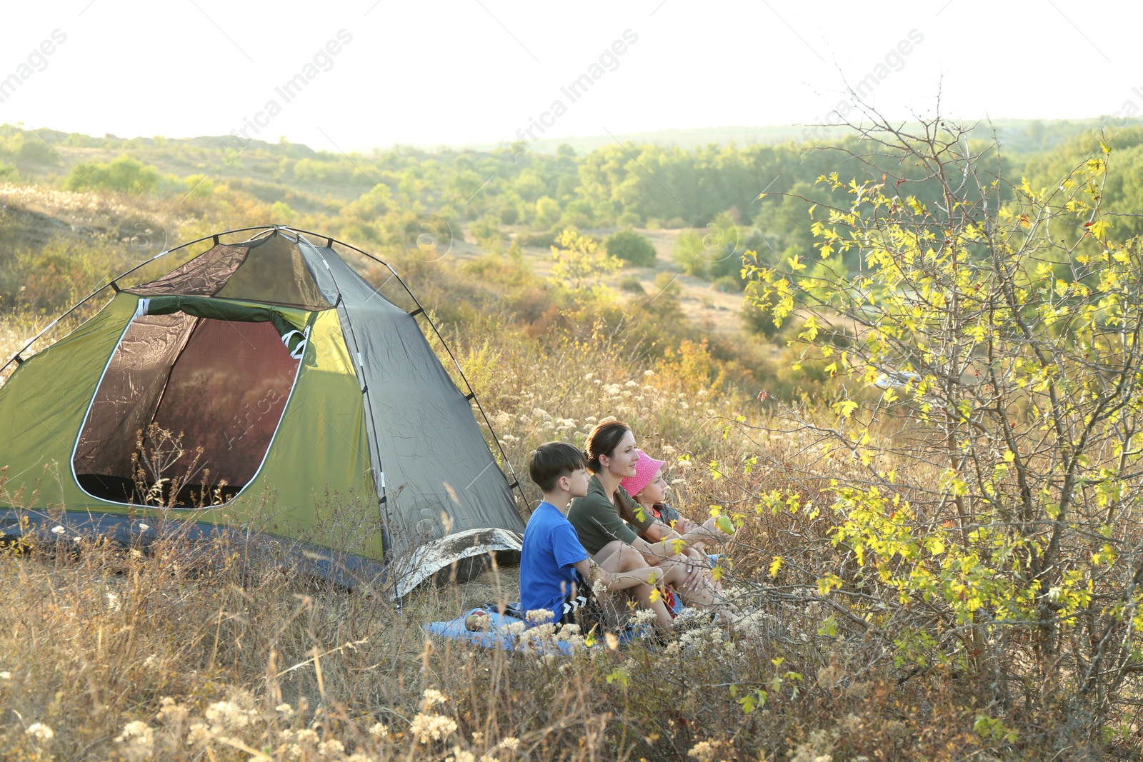 Photo of Family enjoying picturesque view near camping tent