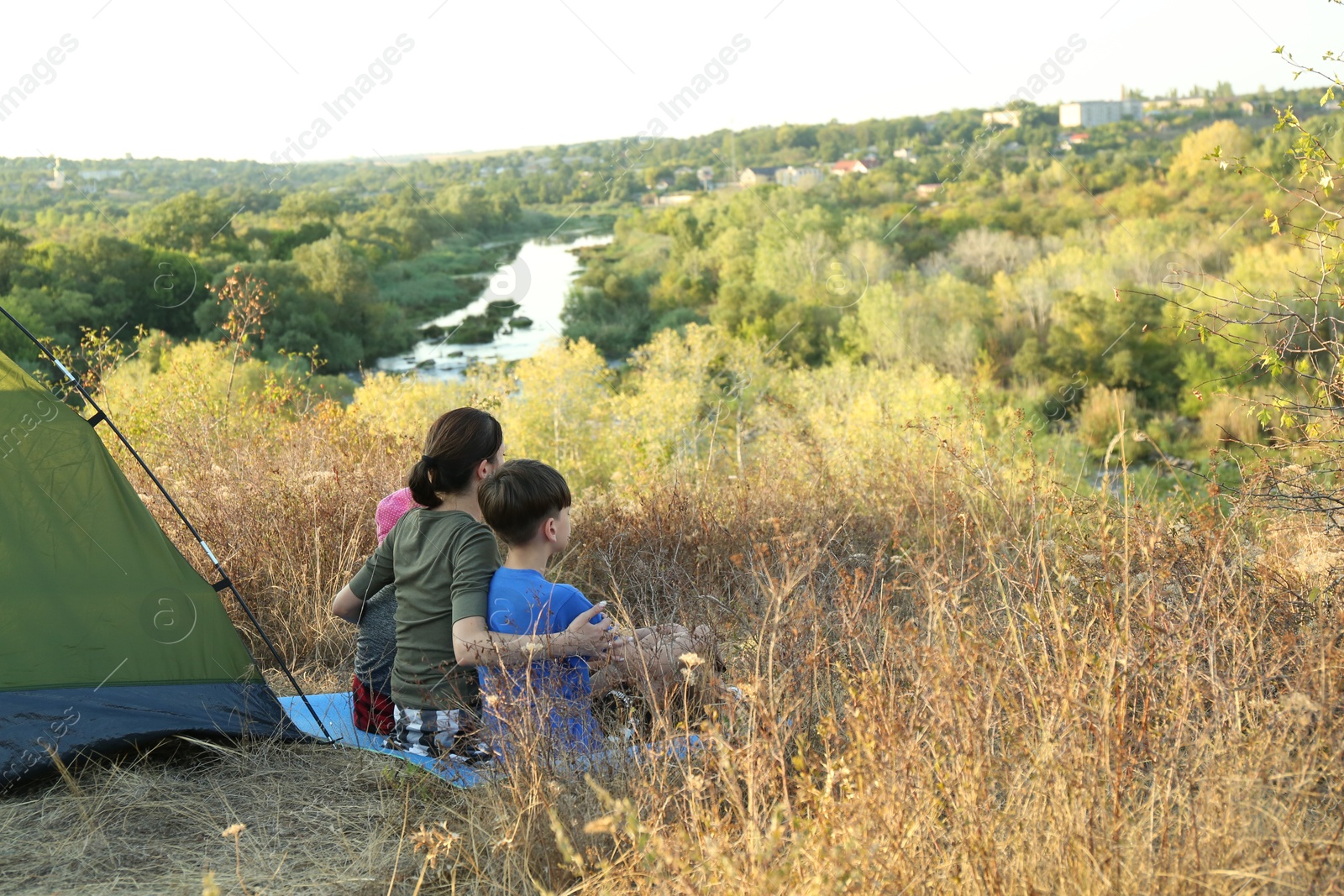 Photo of Family enjoying picturesque view near camping tent