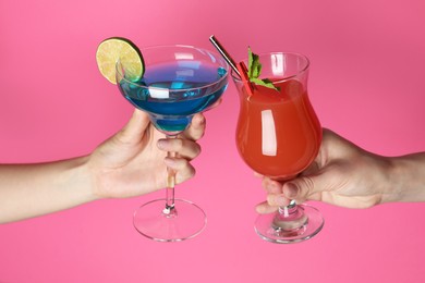 Photo of Friends with glasses of refreshing cocktails on pink background, closeup