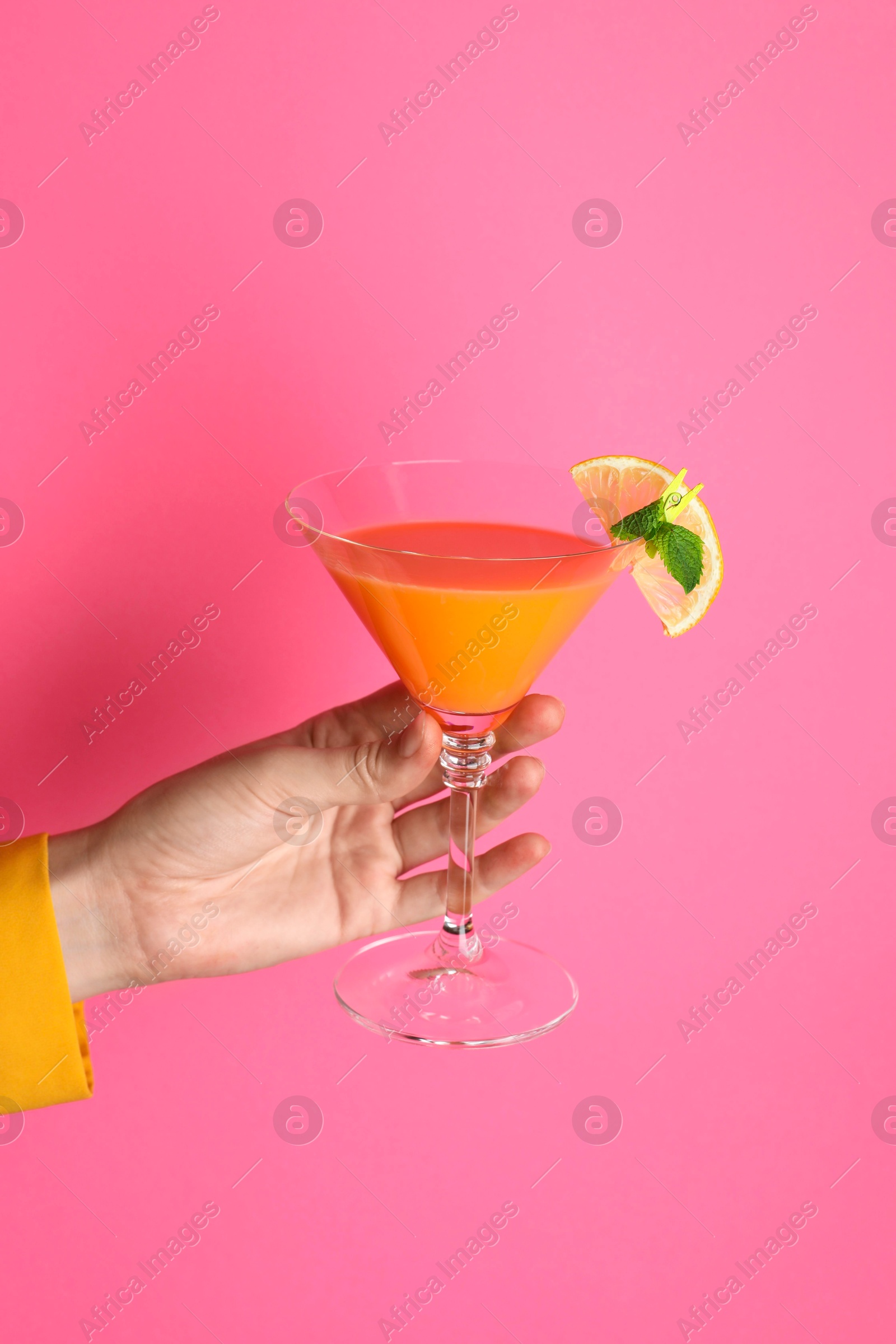 Photo of Woman with glass of refreshing cocktail on pink background, closeup