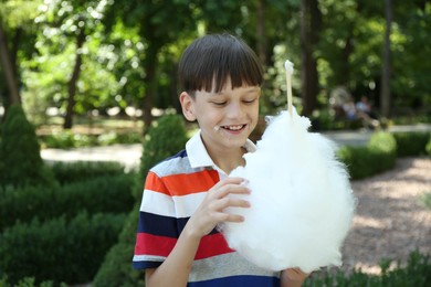 Photo of Portrait of little boy eating sweet cotton candy in park