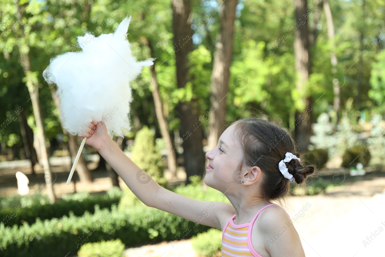 Photo of Portrait of little girl with sweet cotton candy in park