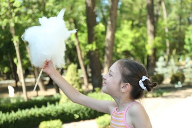 Photo of Portrait of little girl with sweet cotton candy in park