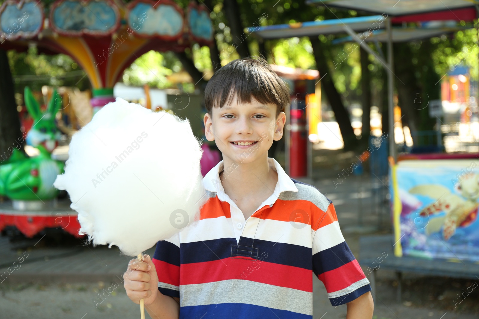 Photo of Portrait of little boy with sweet cotton candy in park