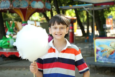 Photo of Portrait of little boy with sweet cotton candy in park