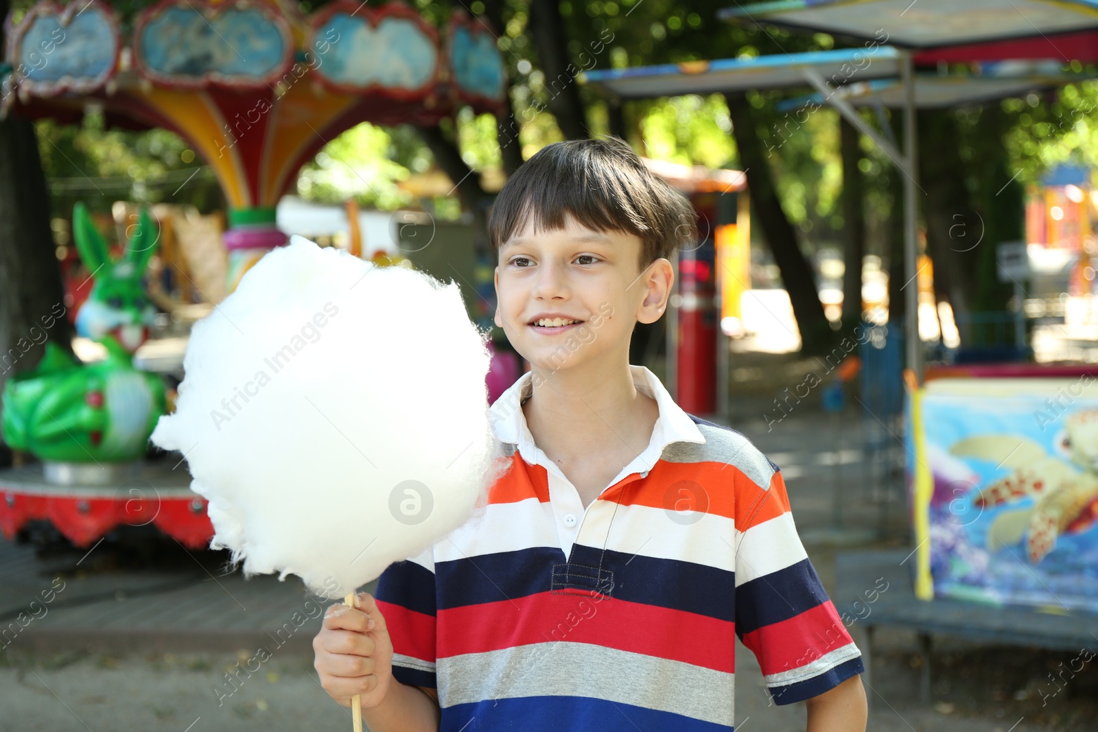 Photo of Portrait of little boy with sweet cotton candy in park