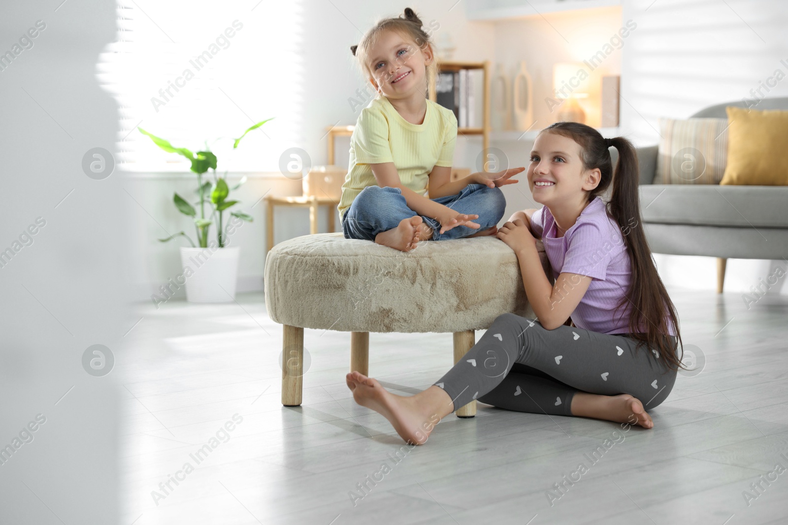 Photo of Cute little sisters spending time together at home