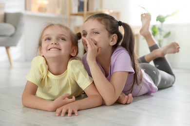 Photo of Cute little sisters spending time together at home