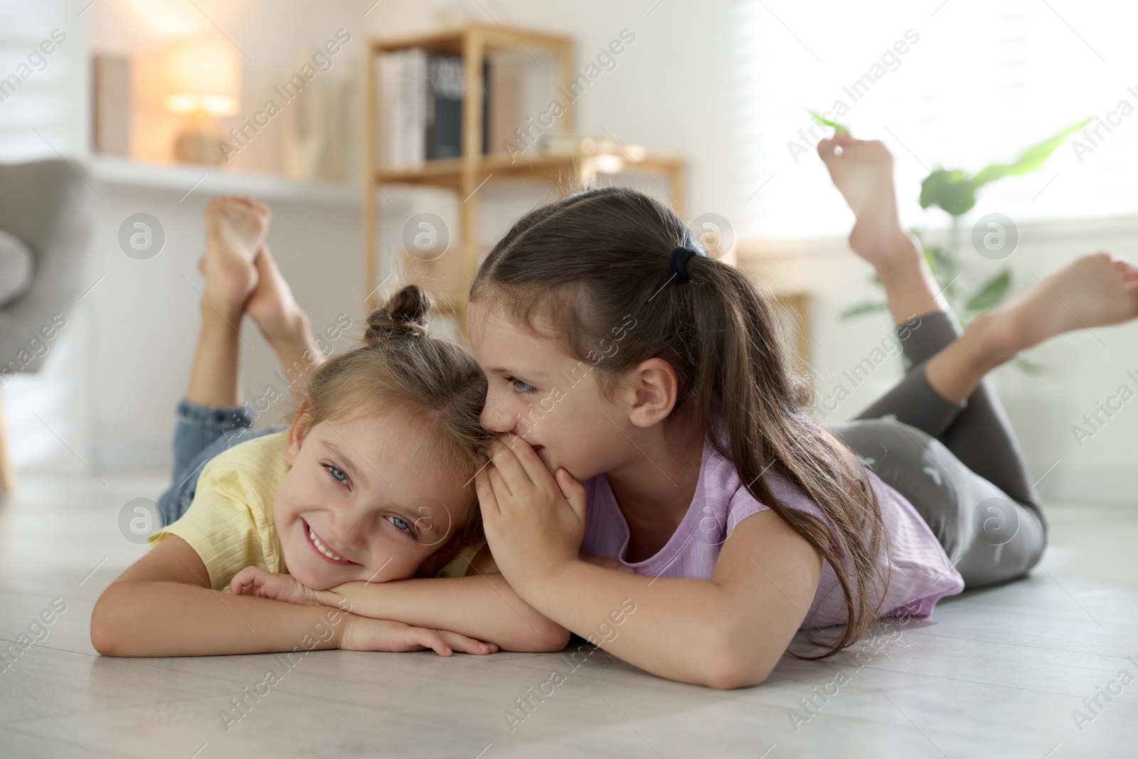 Photo of Cute little sisters spending time together at home