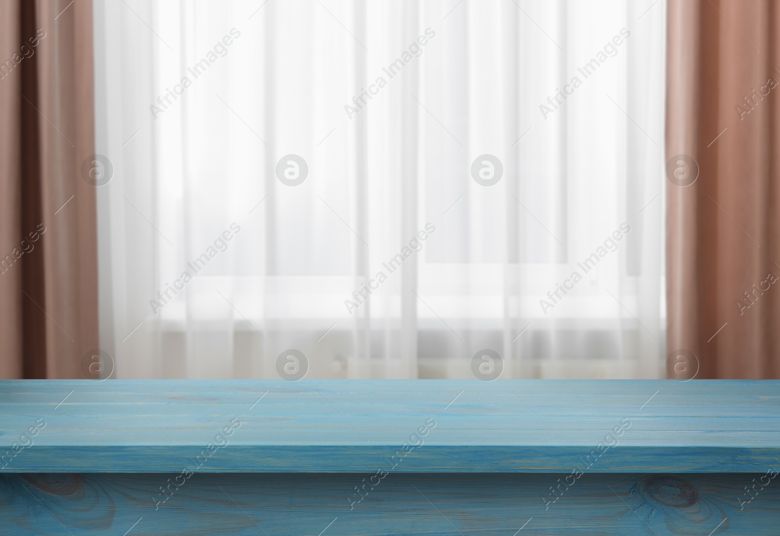 Image of Empty light blue wooden table near window with curtains. Space for design