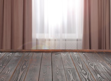 Image of Empty wooden table near window with curtains. Space for design