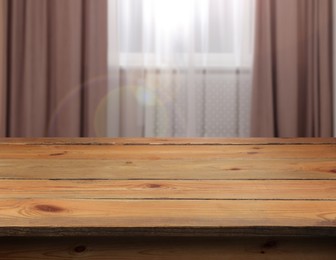 Image of Empty wooden table near window with curtains. Space for design