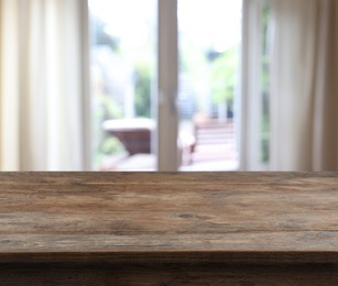 Image of Empty wooden table near window with curtains. Space for design