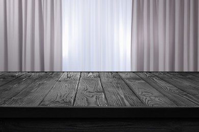 Image of Empty black wooden table near window with curtains. Space for design