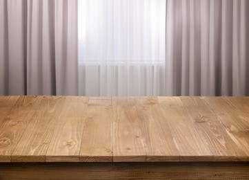 Image of Empty wooden table near window with curtains. Space for design