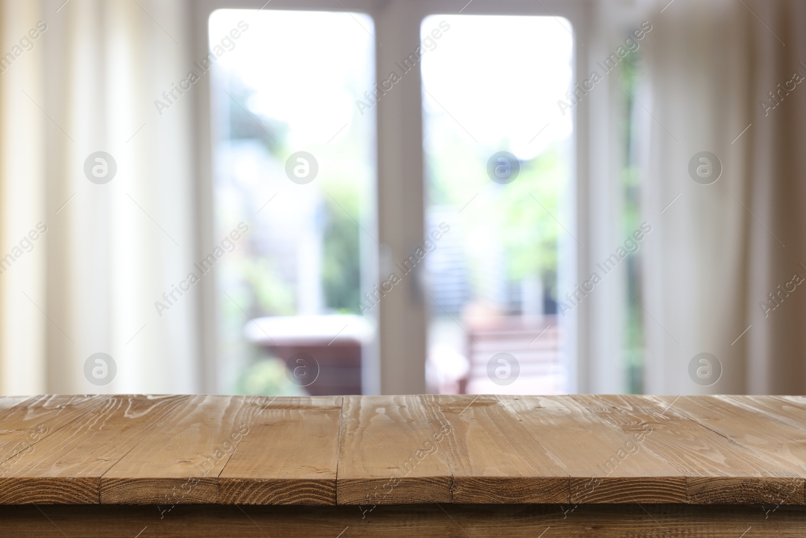 Image of Empty wooden table near window with curtains. Space for design