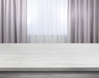 Image of Empty white wooden table near window with curtains. Space for design