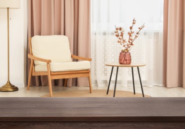 Image of Empty wooden table near armchair, side table and window with curtains. Space for design