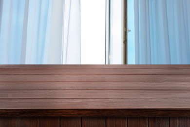 Image of Empty wooden table near window with curtains. Space for design