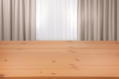 Image of Empty wooden table near window with curtains. Space for design