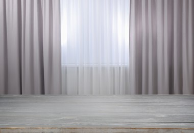 Image of Empty wooden table near window with curtains. Space for design